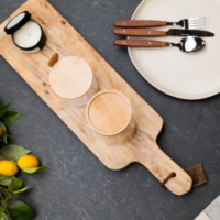 Gedekte tafel met houten snijplank, servies en citroentakken.